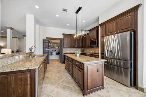 a kitchen with stainless steel appliances granite countertop a sink a stove and a refrigerator