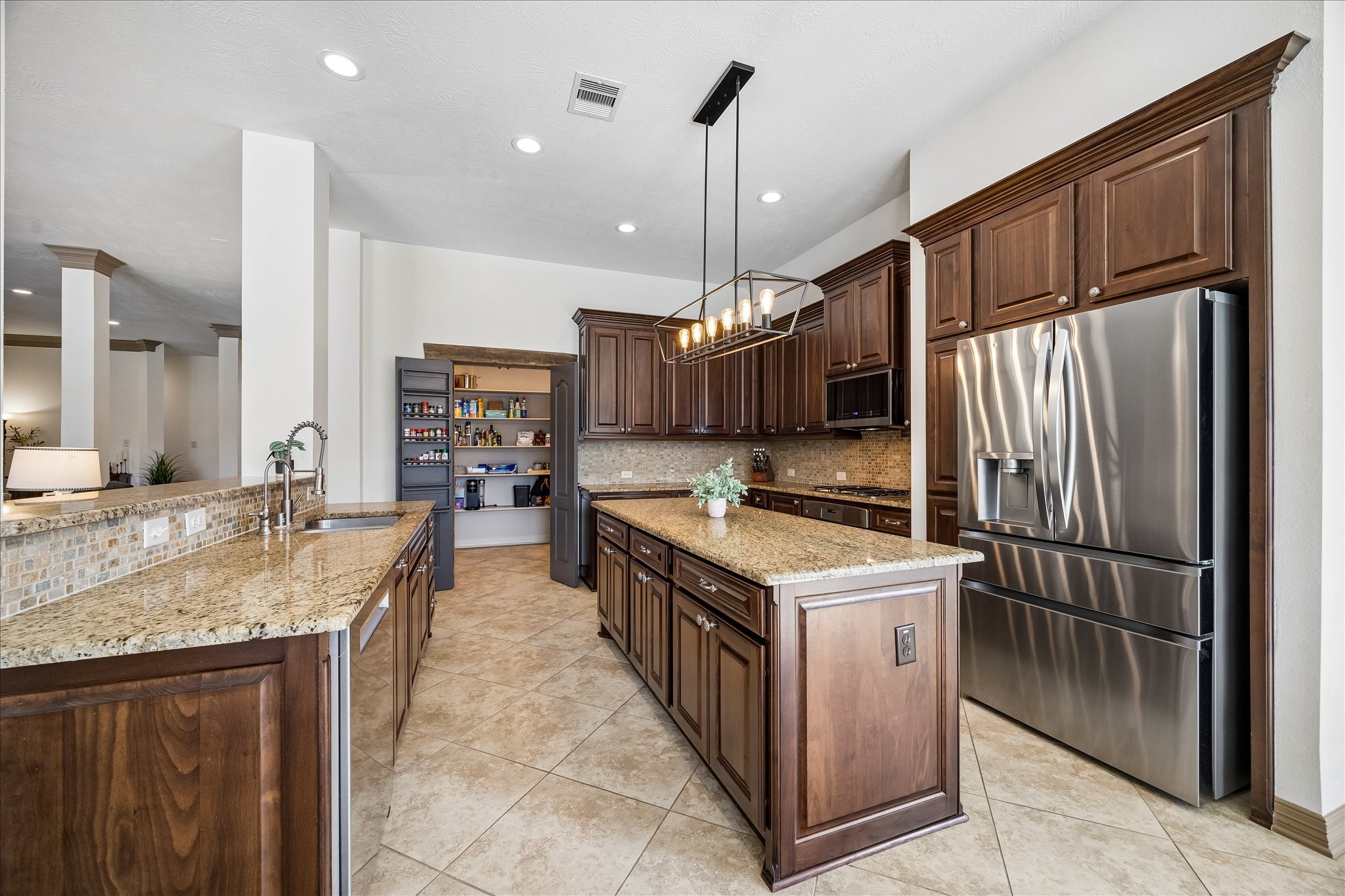 28211 Rippling Brook Lane Fulshear, TX 77441 - Photo 10 of 45 a kitchen with stainless steel appliances granite countertop a sink a stove and a refrigerator