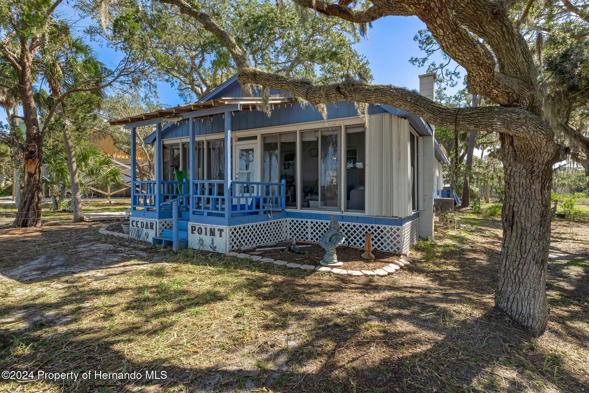 8122 Camp Lane Aripeka, FL 34679 - Photo 20 of 40 a view of a house with a small yard and large tree