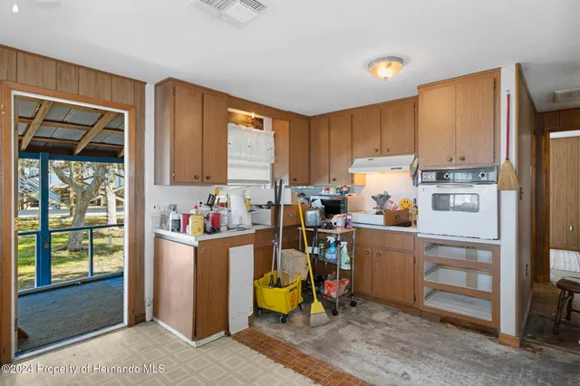 a view of a kitchen with fridge and workspace
