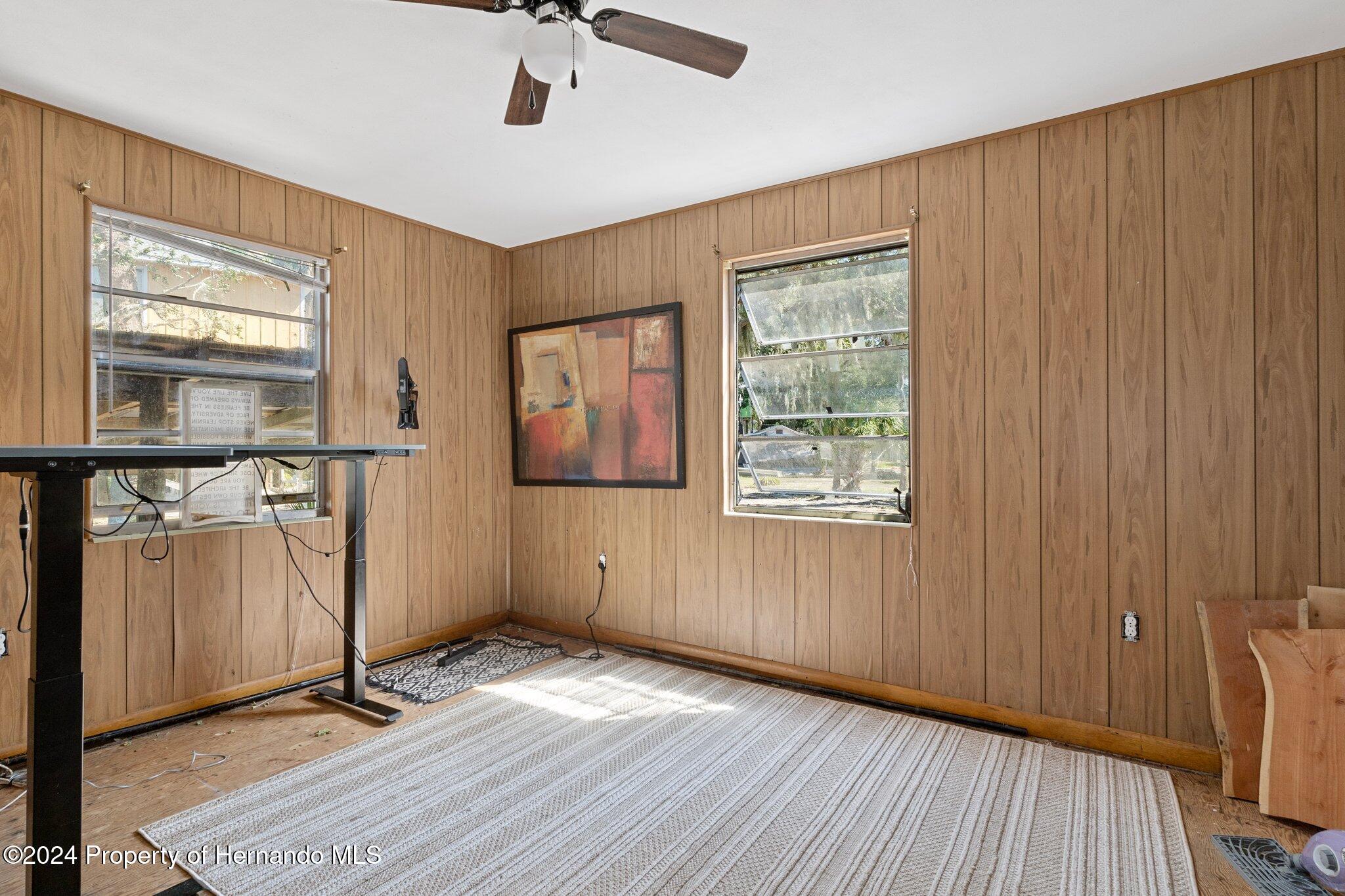 8122 Camp Lane Aripeka, FL 34679 - Photo 31 of 40 a view of empty room with wooden floor and fan
