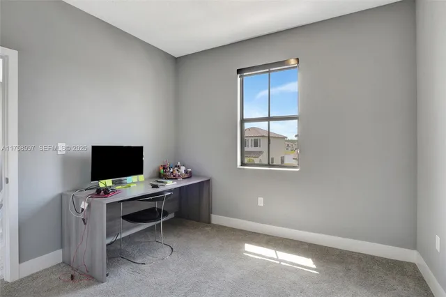 a view of a workspace with furniture and a window