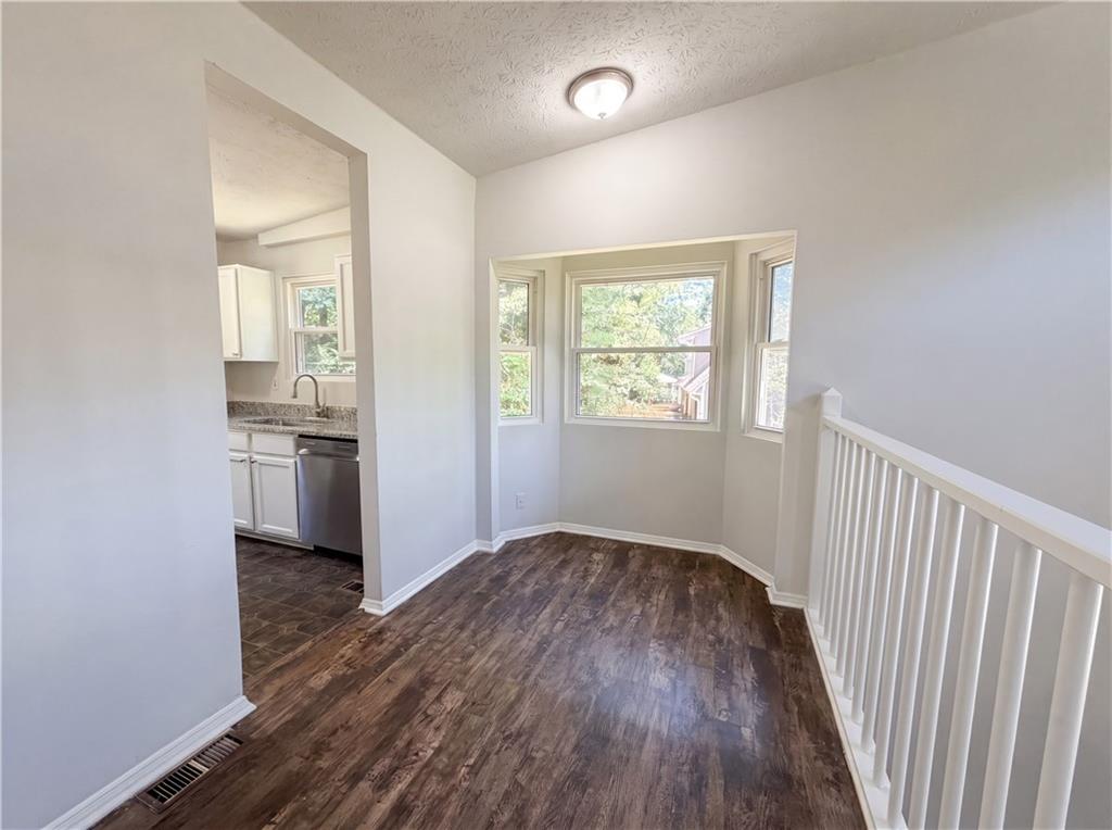6830 Earlhurst Road Atlanta, GA 30349 - Photo 12 of 27 an empty room with wooden floor kitchen view and a window