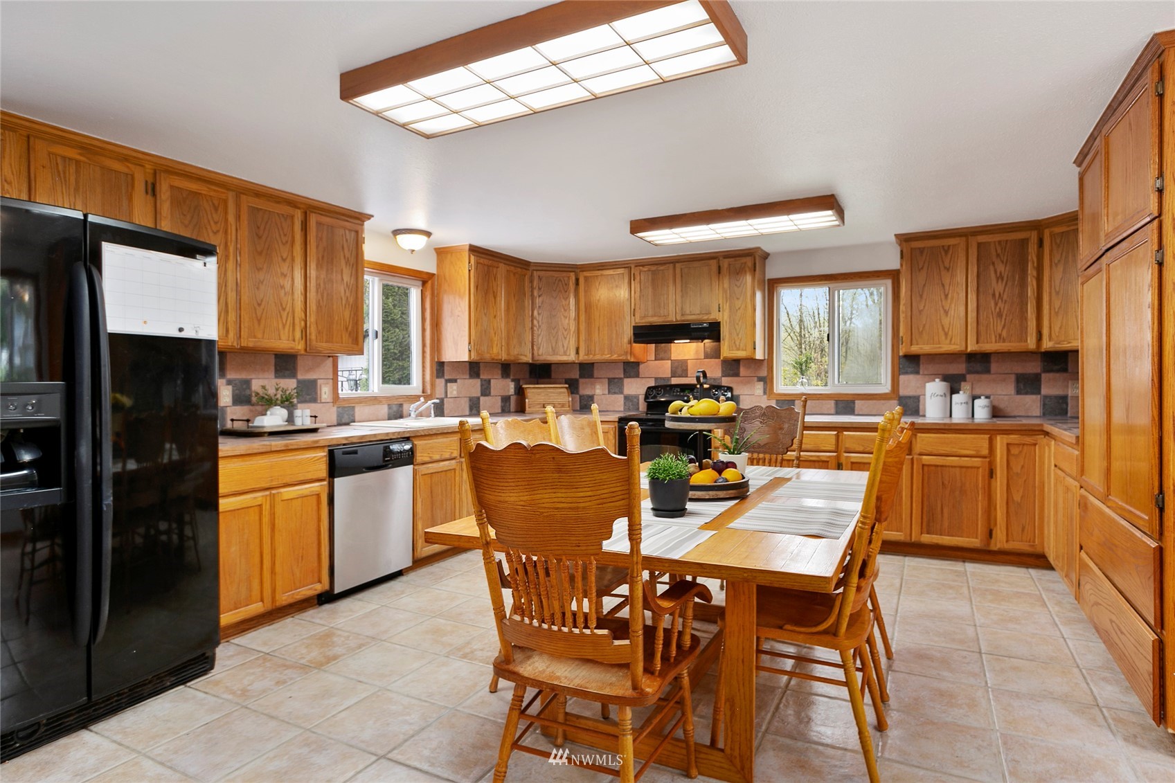 5191 Wickersham Road Acme, WA 98220 - Photo 5 of 23 a kitchen with stainless steel appliances kitchen island granite countertop a refrigerator a stove a sink a dining table and chairs