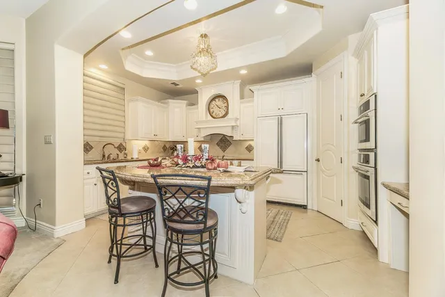 a large white kitchen with cabinets