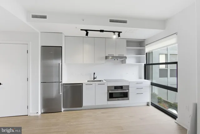 a kitchen with white cabinets and white appliances