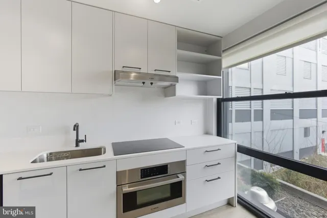 a kitchen with a sink a refrigerator and cabinets