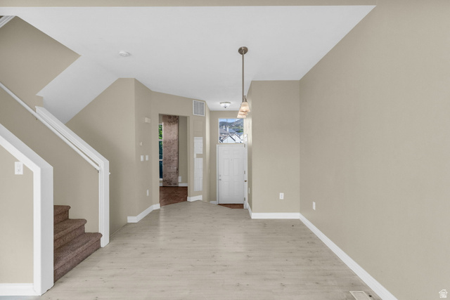 14108 Pepi Band Road Draper, UT 84020 - Photo 7 of 36 Open-concept area featuring light wood-finish flooring, neutral wall paint, and a modern pendant light fixture