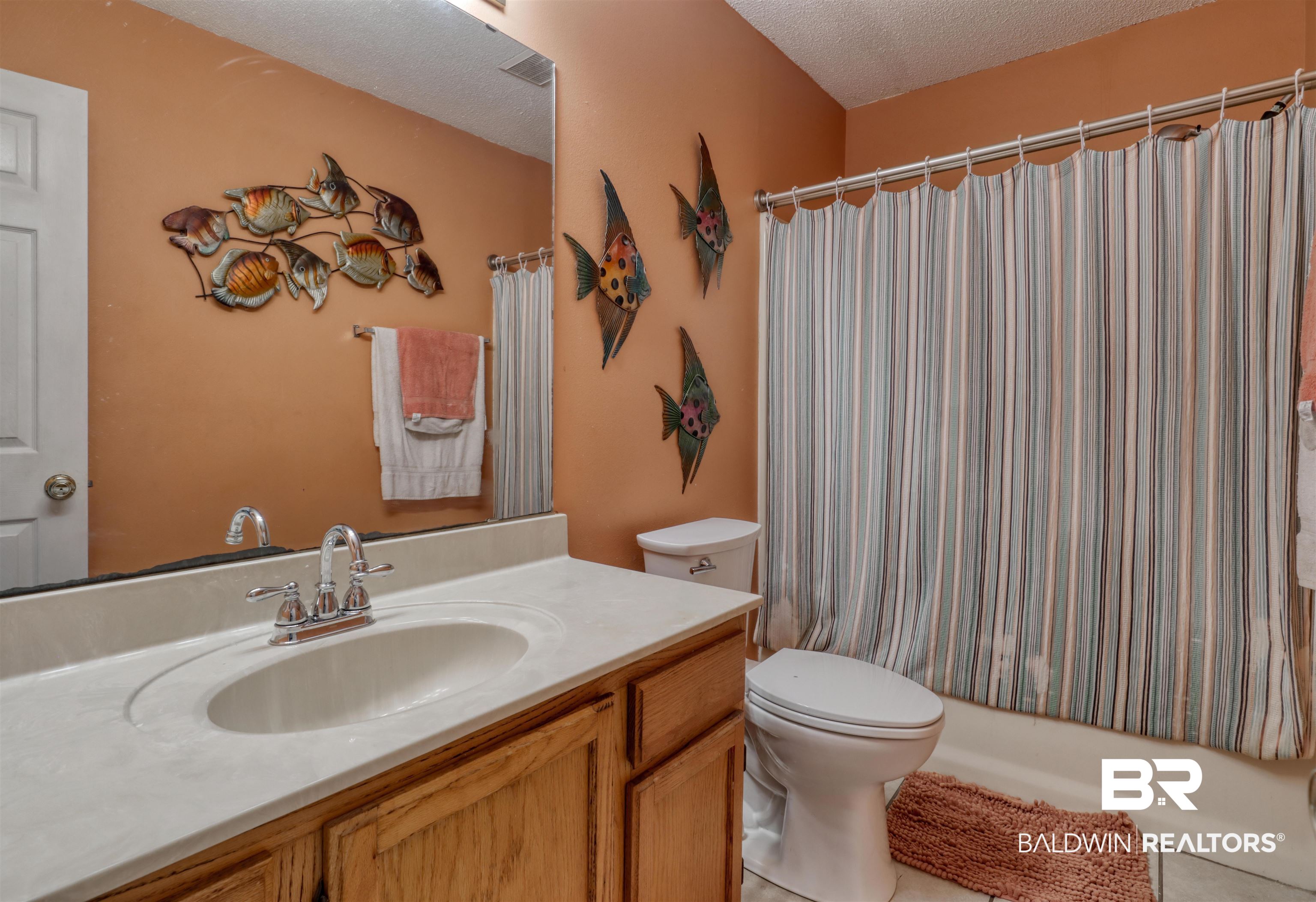 3200 Loop Road, Unit 61 Orange Beach, AL 36561 - Photo 15 of 32 Full bathroom with a textured ceiling, vanity, shower / bath combination with curtain, and tile patterned flooring
