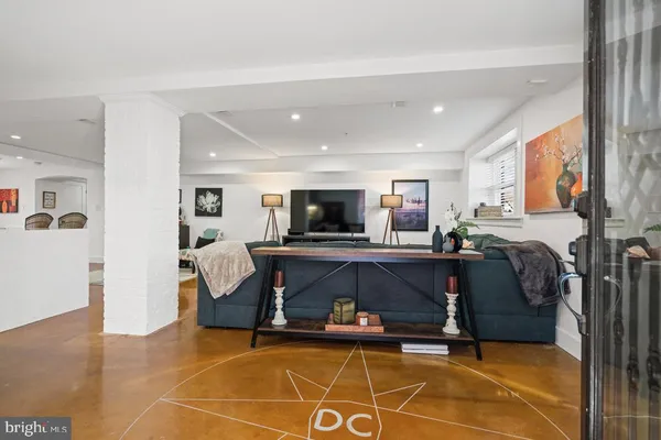 a living room with furniture a flat screen tv and kitchen view