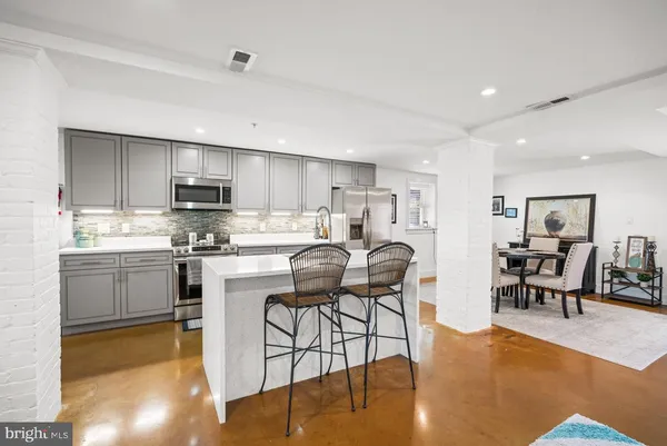 a kitchen with a table chairs microwave and cabinets