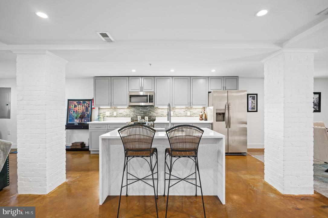 1239 Simms Place Northeast, Unit 5 Washington, DC 20002 - Photo 8 of 31 a kitchen with stainless steel appliances kitchen island granite countertop a refrigerator a stove a sink dishwasher and white cabinets with wooden floor