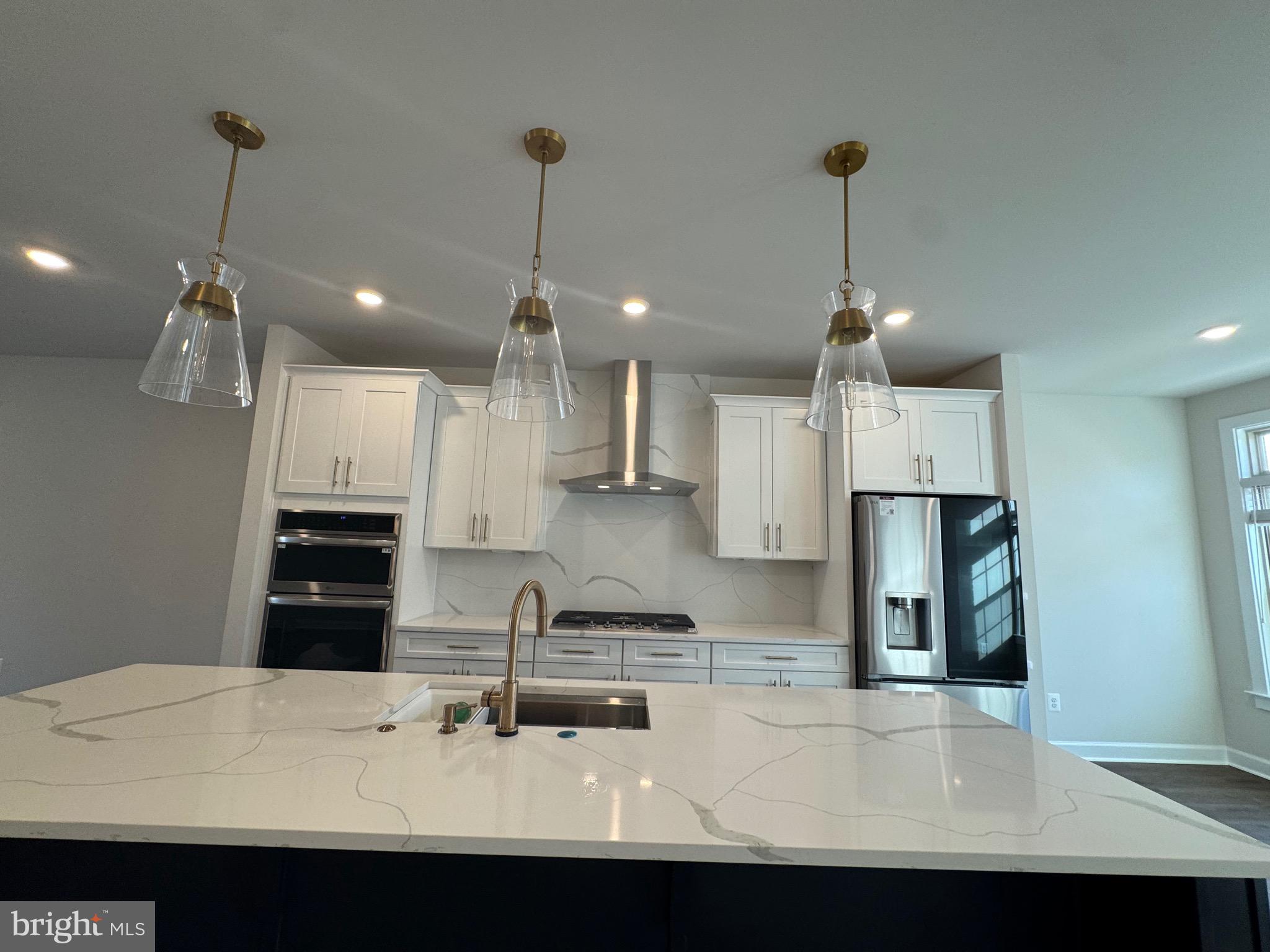 3775 Mayors Way Fairfax, VA 22030 - Photo 33 of 42 a kitchen with kitchen island white cabinets and refrigerator