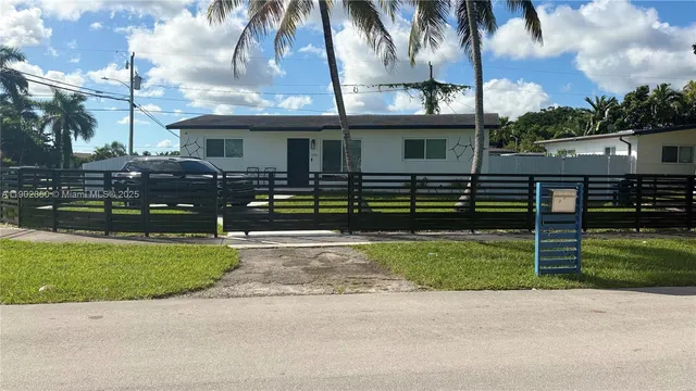 a front view of a house with a garden and yard