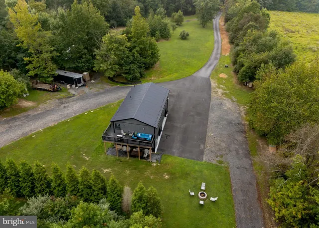 an aerial view of a house with a yard and lake view