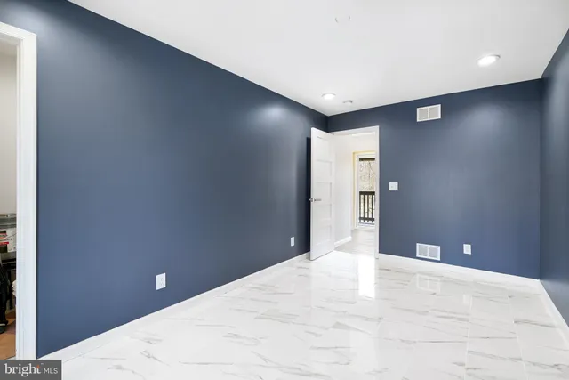 a bathroom with a toilet and a painting on the wall