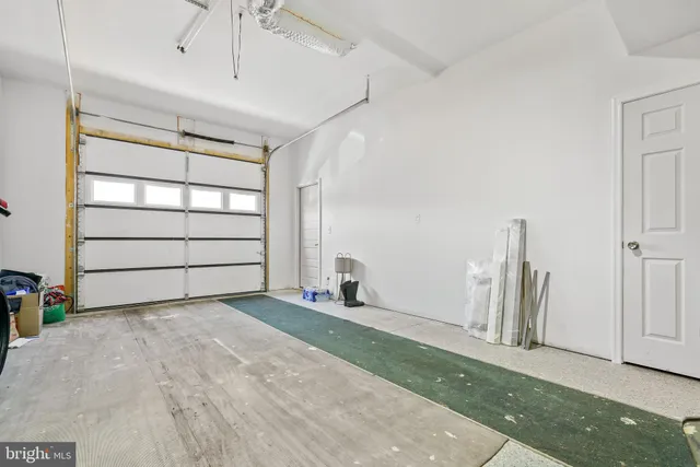 a view of an empty room with wooden floor and windows
