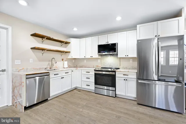 a bathroom with a bathtub shower sink vanity mirror and toilet