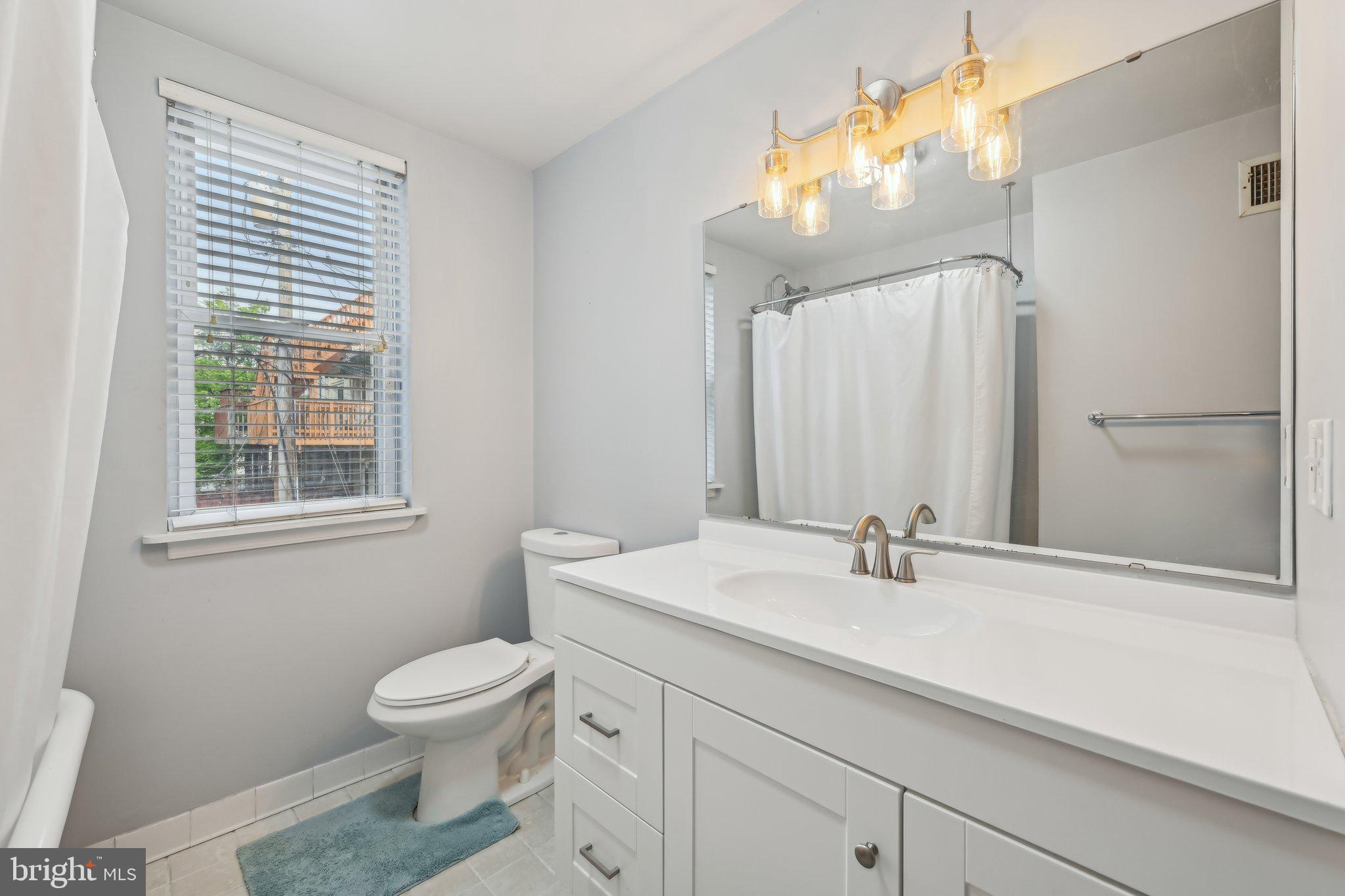 935 South Kenwood Avenue Baltimore, MD 21224 - Photo 14 of 25 a bathroom with a sink a toilet and mirror