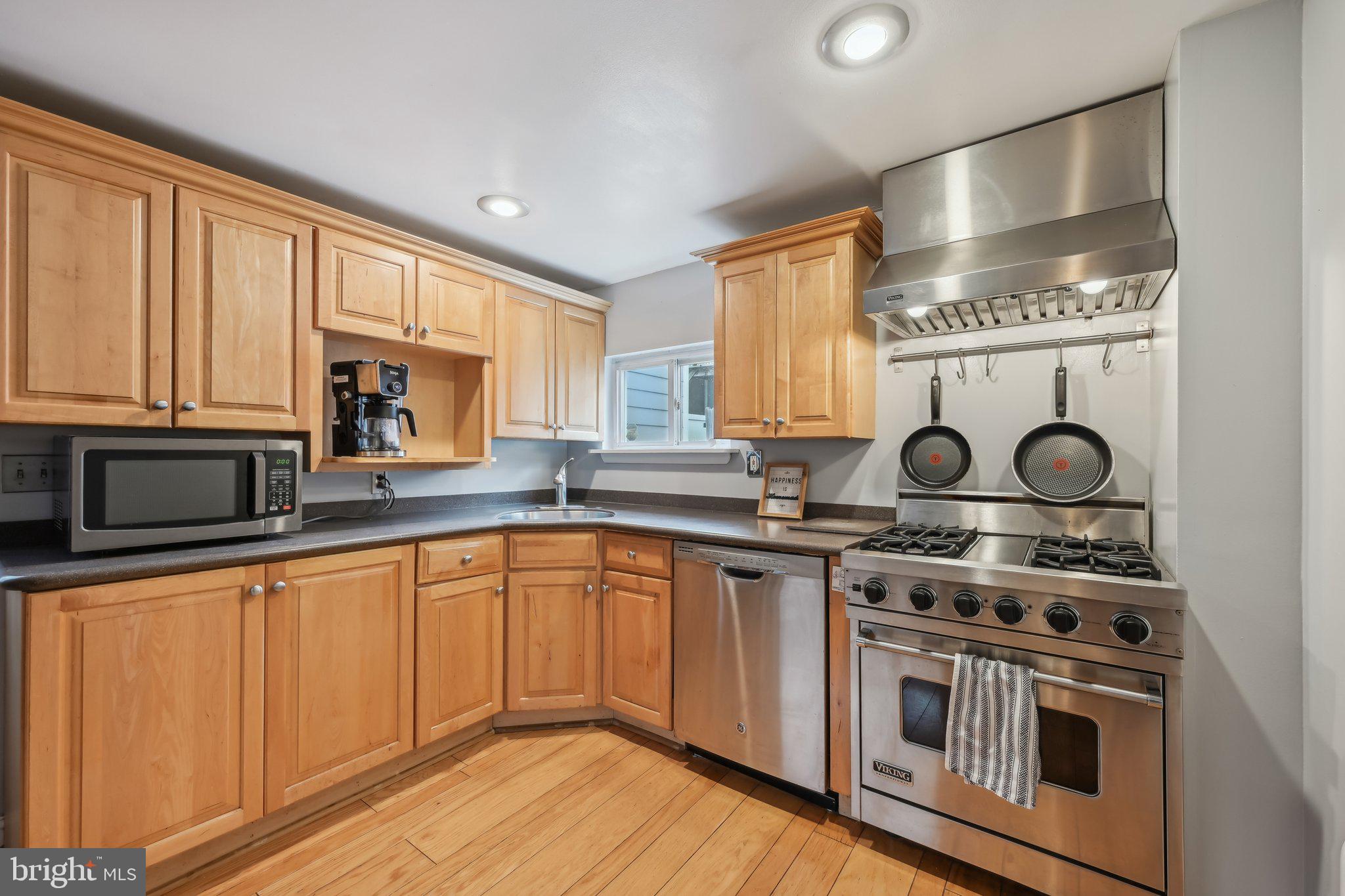 935 South Kenwood Avenue Baltimore, MD 21224 - Photo 10 of 25 a kitchen with wooden cabinets and a stove top oven