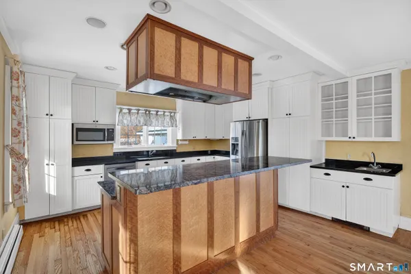 a kitchen with stainless steel appliances granite countertop a stove and cabinets