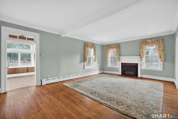 an empty room with windows and fireplace