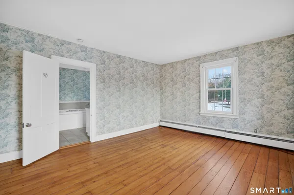 wooden floor in an empty room with a window