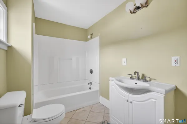 a bathroom with a sink mirror toilet and bathtub