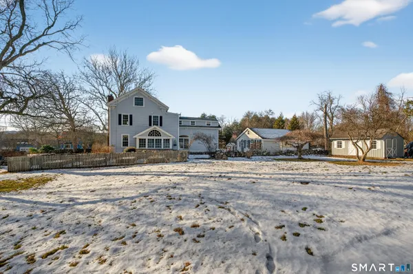 a front view of a house with a yard covered in snow