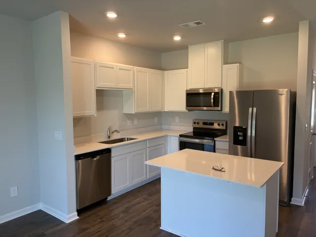 a kitchen with kitchen island a sink stainless steel appliances and cabinets