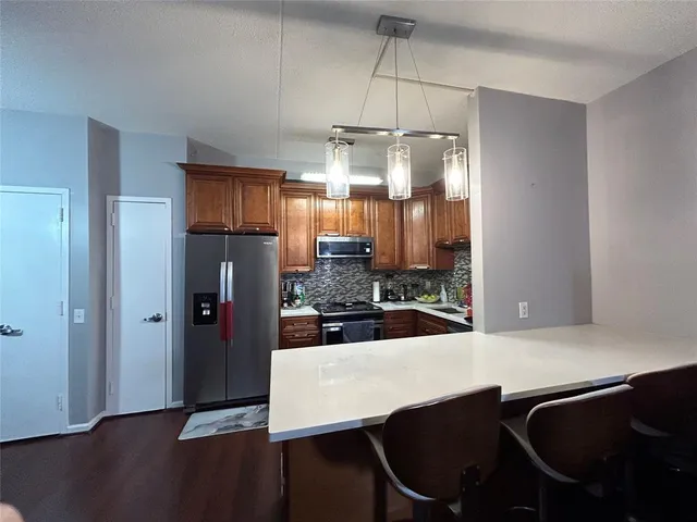 a kitchen with stainless steel appliances a dining table chairs and granite counter tops