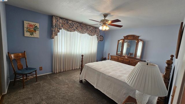 a bedroom with a bed a dresser and chair