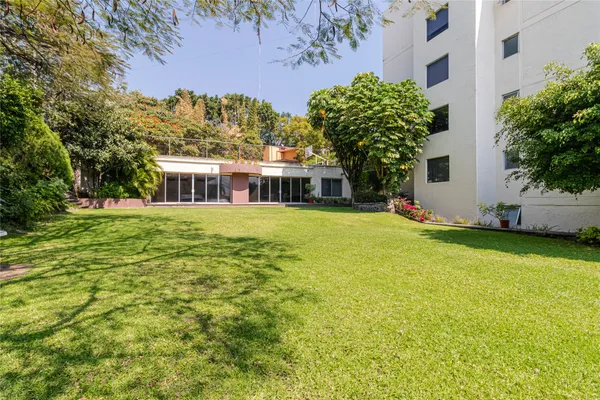 a view of a house with a garden and trees