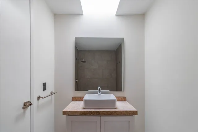 a bathroom with a granite countertop sink mirror and toilet