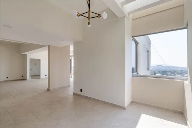 a view of empty room with wooden floor and window