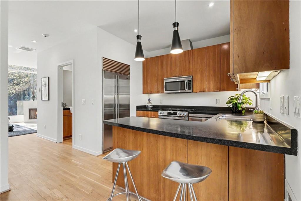 2465 Field Way Atlanta, GA 30319 - Photo 14 of 40 a kitchen with stainless steel appliances granite countertop a refrigerator a sink dishwasher a stove and a dining table with wooden floor