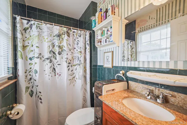 a bathroom with a granite countertop sink toilet and shower