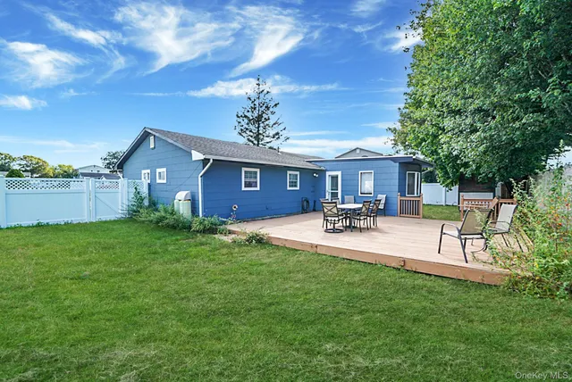 a view of a patio with a table and chairs with wooden fence