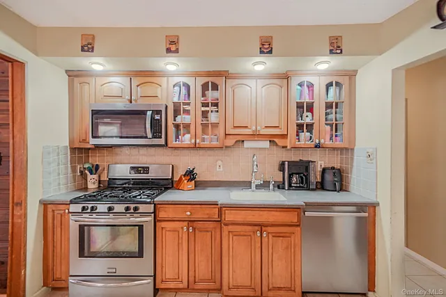a kitchen with stainless steel appliances granite countertop a stove a sink and a microwave