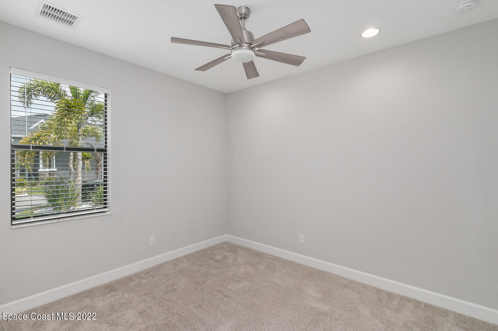 3289 Ribbon Grass Drive Melbourne, FL 32940 - Photo 13 of 58 an empty room with a window and a fan