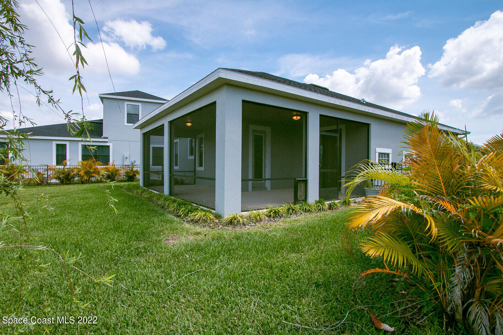 3289 Ribbon Grass Drive Melbourne, FL 32940 - Photo 17 of 58 a yellow house with flower garden in front of it