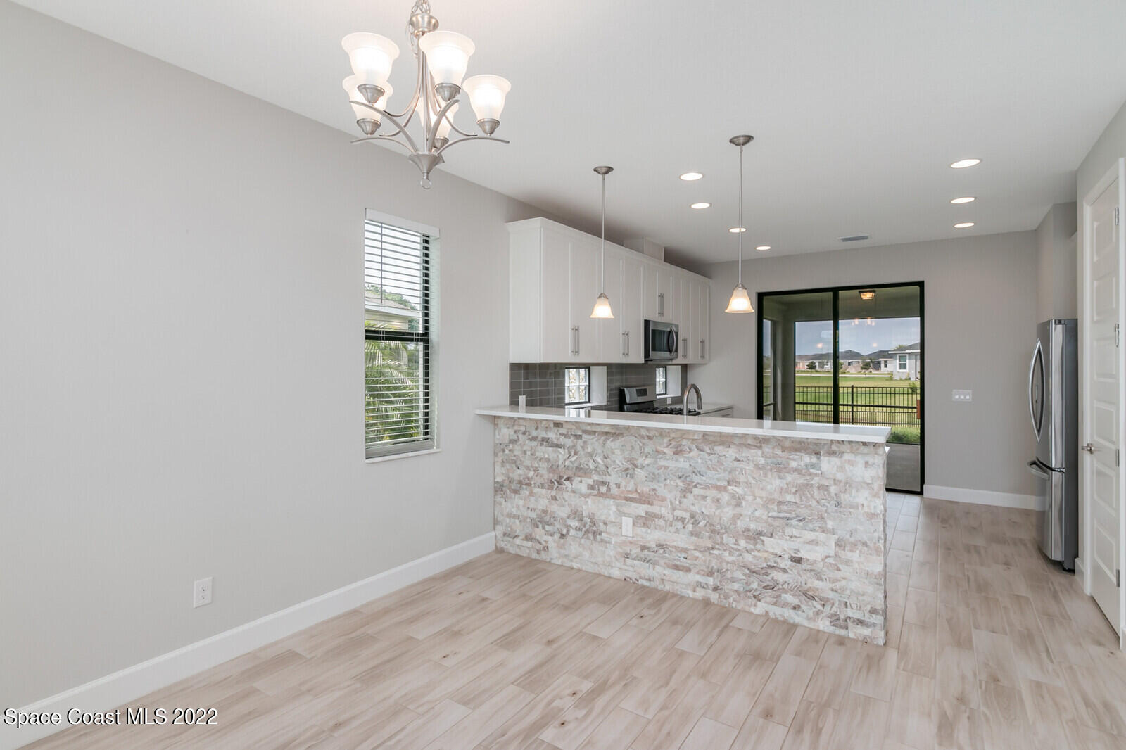 3289 Ribbon Grass Drive Melbourne, FL 32940 - Photo 6 of 58 a large kitchen with kitchen island white cabinets and stainless steel appliances