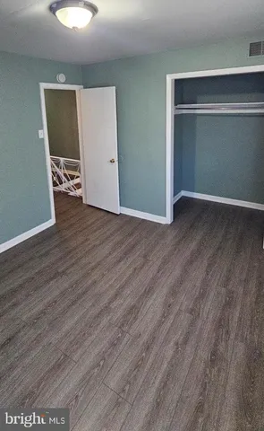 an empty room with wooden floor and closet