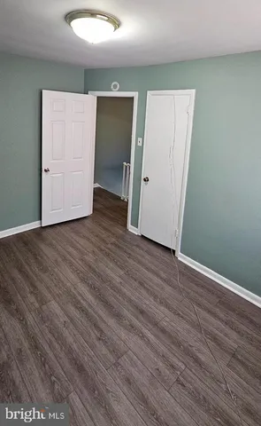 an empty room with wooden floor and closet