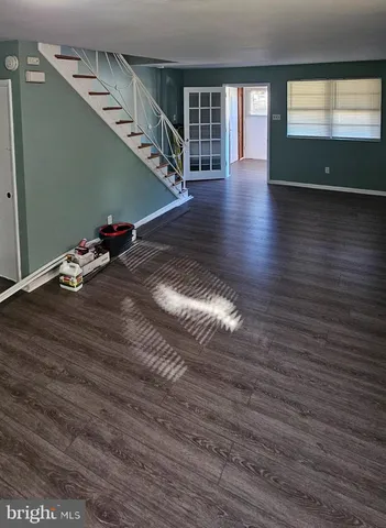 a room with wooden floor and windows