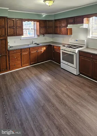 a kitchen with stainless steel appliances granite countertop a stove a sink and a refrigerator