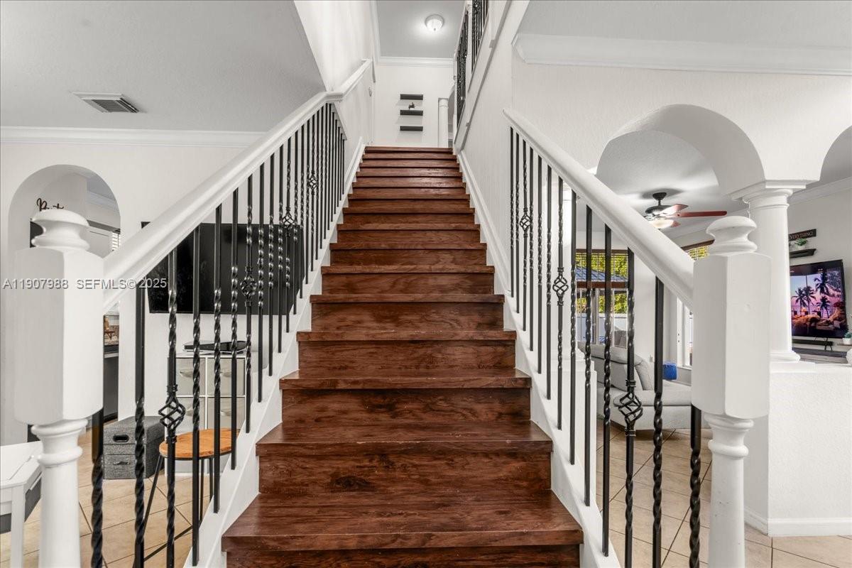 14027 Southwest 274th Terrace Homestead, FL 33032 - Photo 33 of 65 a view of staircase with lots of frames on wall and wooden floor