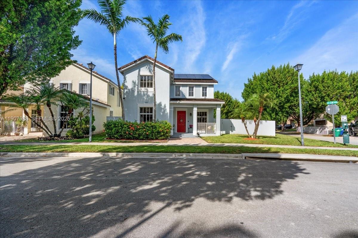14027 Southwest 274th Terrace Homestead, FL 33032 - Photo 4 of 65 a view of a house with a yard and palm trees