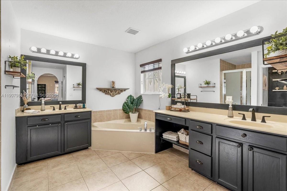 14027 Southwest 274th Terrace Homestead, FL 33032 - Photo 51 of 65 a spacious bathroom with a granite countertop sink mirror and bathtub
