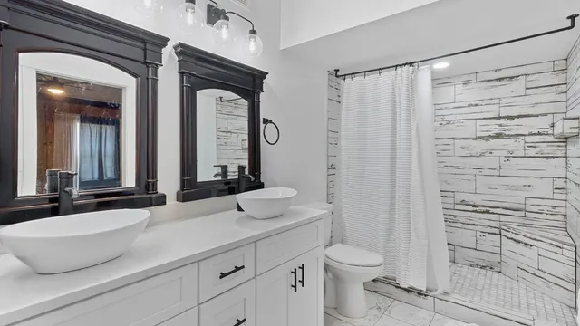 a bathroom with a granite countertop sink a toilet and a mirror